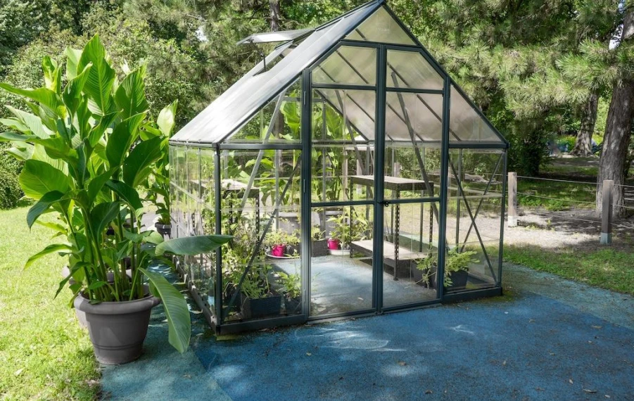 Záhradný skleník na pevnom betónovom základe v jesennej záhrade
